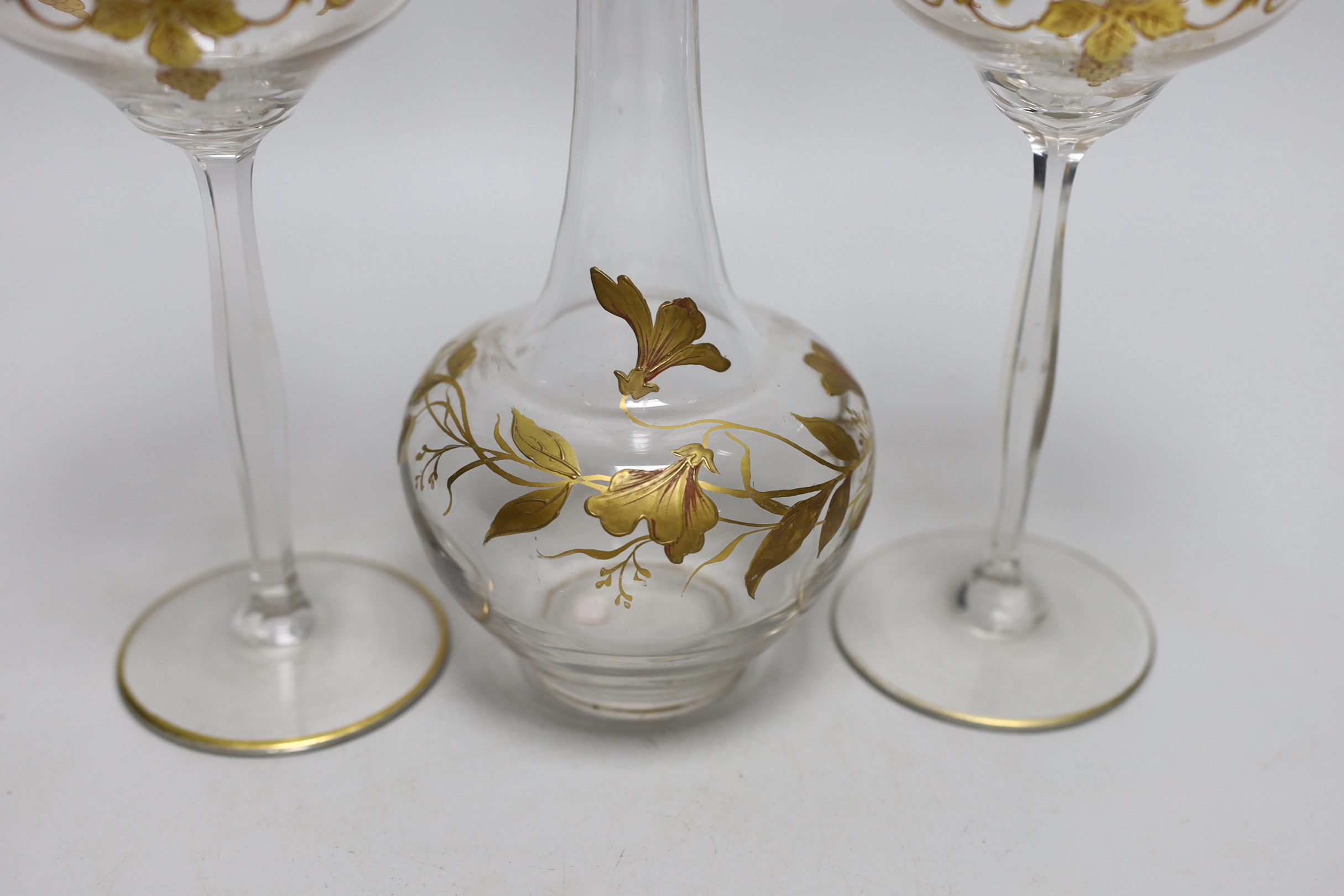 A Continental Art Nouveau gilt glass decanter and a pair of similar glasses, decanter 24cm high